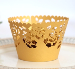Macro shot of gold laser-cut cupcake wrapper with floral patterns and a chocolate ball