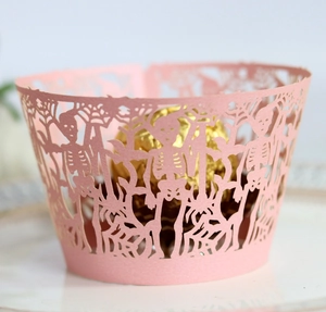 Detailed laser-cut pink cupcake wrapper with skull and dead tree Halloween patterns