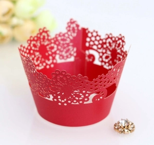 Detail of red laser-cut cupcake wrapper featuring intricate lace floral patterns
