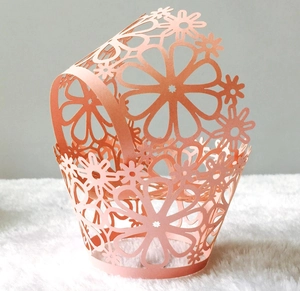 Laser cut floral cupcake wrappers in peach pink for wedding and party cake decorations