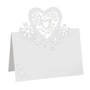 Close-up of white laser-cut heart and floral hollow patterns on folded cardstock