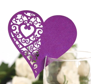 Close-up of a purple heart laser-cut place card attached to a wine glass for weddings