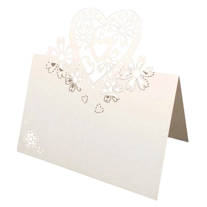 Macro detail of white hollow heart laser-cut name place card for wedding table decor