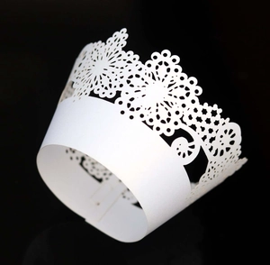 Detail of laser-cut floral crown patterns on white lace cupcake paper wrappers
