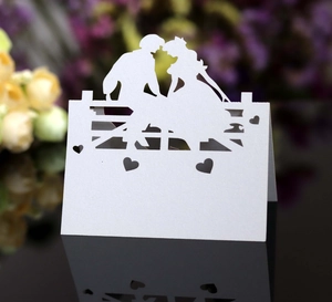 Detail einer lasergeschnittenen Hochzeitsplatzkarte mit romantischer Silhouette und Herzausschnitten