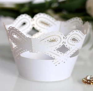 Elegant white laser-cut cupcake wrappers with lace crown pattern and hollow bow details