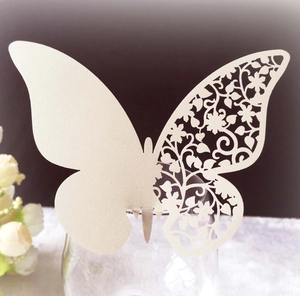 Elegant cream butterfly place card with intricate laser-cut floral design for glass rim