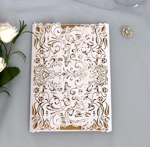 Macro detail of laser-cut wedding invitation with elegant white baroque hollow patterns
