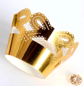 Macro detail of laser-cut hollow crown cake border in reflective mirror gold cardstock