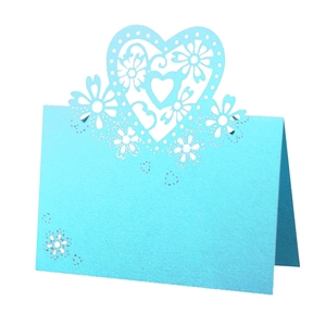 Detail of light blue laser-cut place card with intricate hollow heart and flower patterns