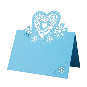 Detail of blue laser-cut heart and floral patterns on elegant paper place cards
