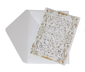 Detail of laser cut wedding invitation showing intricate white cardstock floral patterns