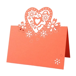 Detailed laser-cut heart hollow place card in coral red paper for wedding table decor