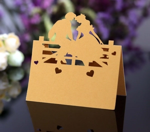 Detaillierte lasergeschnittene Tischkarte mit romantischem Paar-Silhouette auf Goldpapier