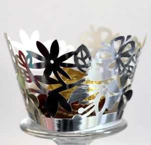 Silver laser-cut floral cake wrapper with intricate flower patterns for wedding decor