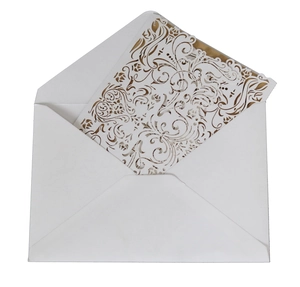 Detail of laser-cut floral wedding invitation with golden inner sheet and white envelope