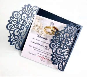 Close-up of laser-cut navy blue wedding invitation with intricate floral lace detail