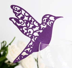Gros plan d'un marque-place colibri violet découpé au laser pour bord de verre