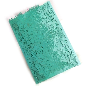 Close-up of laser-cut floral details on mint green pearlescent paper invitation card