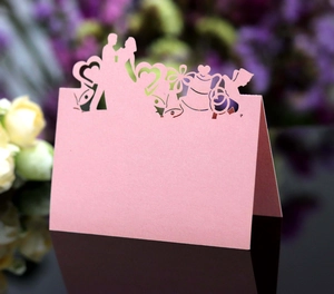 Détail de marque-place de mariage découpé au laser avec silhouettes romantiques roses