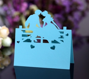 Nahaufnahme der himmelblauen Platzkarte mit Laser-Cut-Paarsilhouette und Herzen