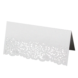 Detailed view of laser-cut white lace patterns on a 3D wedding table place card
