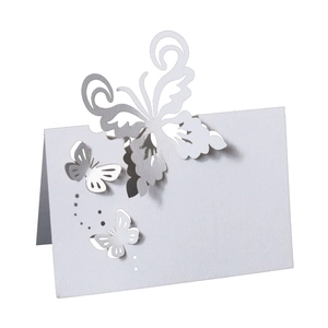 Detailed laser-cut white butterfly place card showing intricate openwork paper patterns