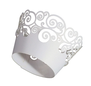 Detail of white laser cut cupcake wrapper with elegant European floral scroll pattern