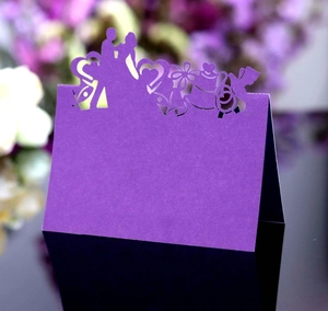 Détail macro du marque-place de mariage violet découpé au laser avec silhouette de mariés