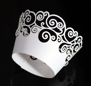 Detailed laser-cut scroll pattern on white pearlescent cupcake wrappers for parties