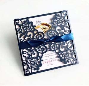 Detail of laser-cut navy blue wedding invitation with elegant satin ribbon bow
