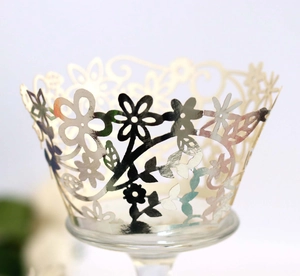 Close-up of laser-cut silver floral hollow cupcake wrapper with metallic finish