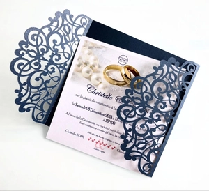 Detail of laser-cut navy blue wedding invitation with gold ring and pearl graphics