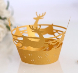 Detail of laser-cut reindeer and snowflake patterns on golden Christmas cupcake wrappers