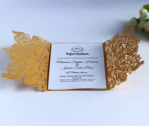 Close-up of laser-cut gold wedding invitation with intricate floral hollowed patterns