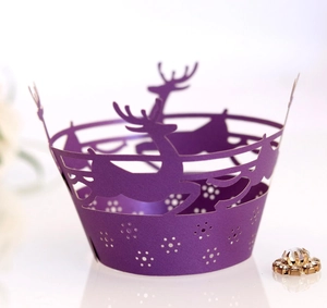 Macro view of purple laser-cut paper cake wrapper with reindeer and snowflake design