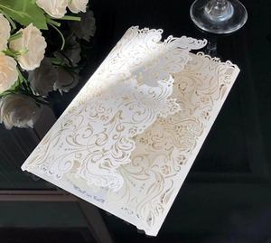 Macro shot of elegant laser-cut invitation card with intricate European scrollwork