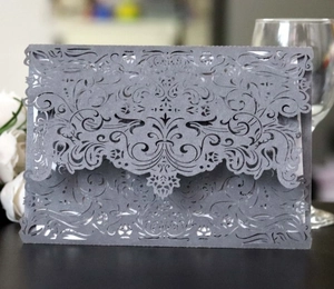Detailed laser-cut grey floral wedding invitation card with white insert and white roses
