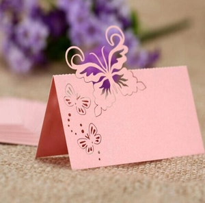 Macro detail of laser-cut pink butterfly place card on rustic burlap background