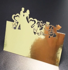 Détail du marque-place doré découpé au laser avec silhouettes de mariés pour mariage chic