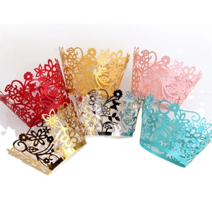Laser-cut floral cupcake wrappers in gold, silver, and pink for wedding party decorations