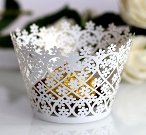 Detailed laser-cut white cupcake wrapper with floral and heart patterns for wedding decor