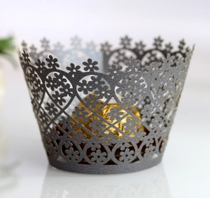 Detail of dark grey laser-cut flower cupcake wrapper with intricate hollow patterns