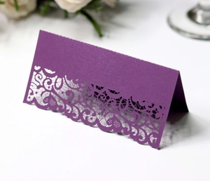 Close-up of laser cut hollow lace pattern on purple wedding tent table card