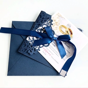 Navy blue laser-cut wedding invitation set with an elegant satin ribbon and envelope