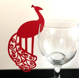 Red laser-cut peacock paper place card for wine glass featuring intricate hollow details