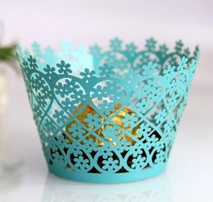 Macro detail of laser-cut tiffany blue cupcake wrapper with intricate floral and heart patterns