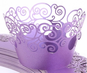 Detail of laser-cut purple pearlescent cupcake wrappers with elegant scrollwork pattern