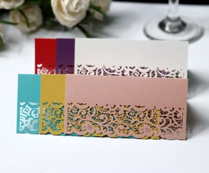 Detail of laser-cut lace place cards in multiple pearlescent colors for wedding decor