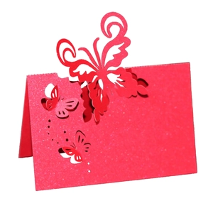 Detail of red laser-cut butterfly place card with sparkling pearl paper texture